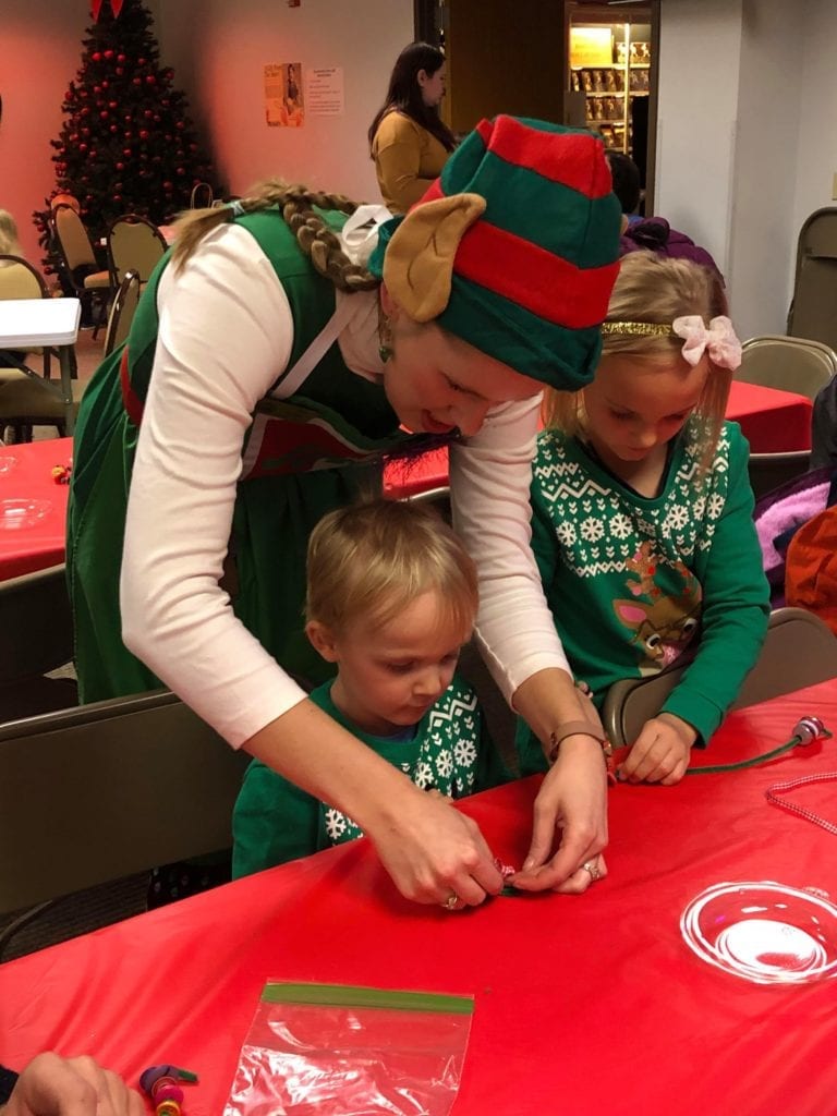 Chloe the Craft Elf helping visitors create a festive take home craft.