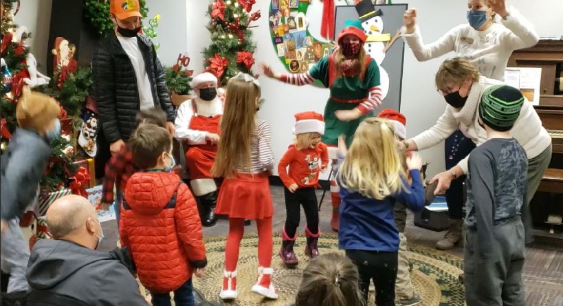 Dancing at Storytime with Santa Barn and log cabin in winter
