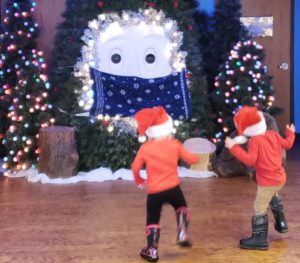 Two children dancing with Bruce the Spruce