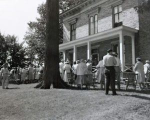 People gathered around brick home in 1954