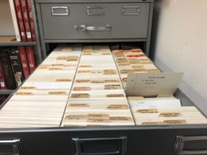 An open drawer with three long rows of index cards.