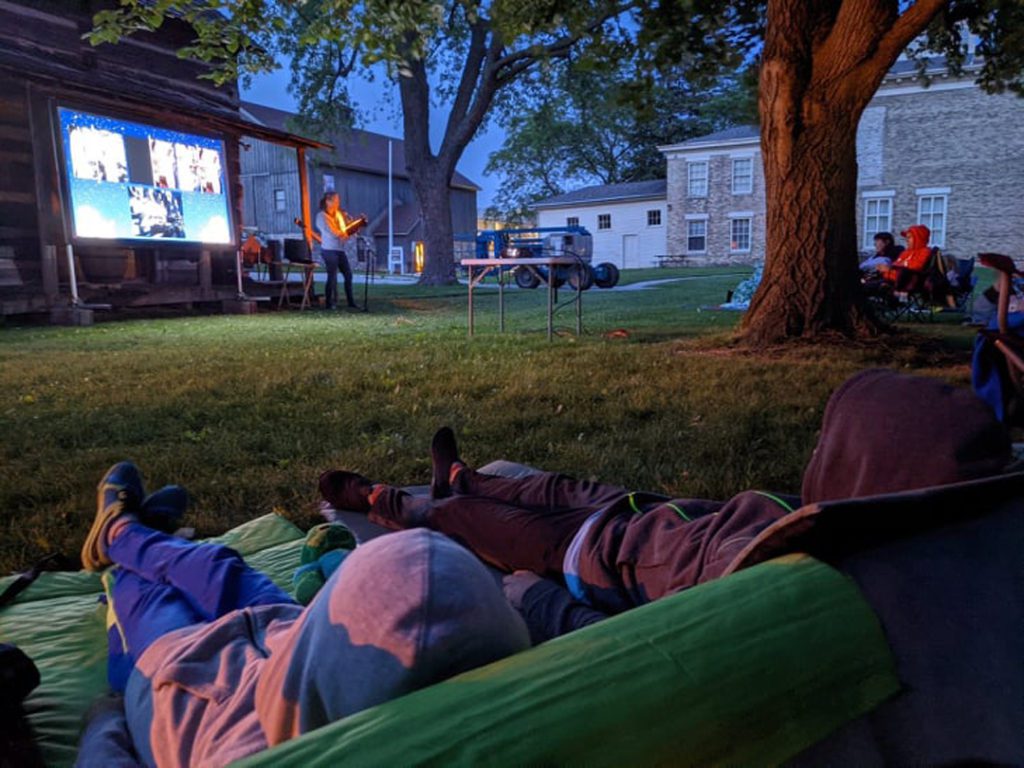 People in lawn chairs with flags listening to music