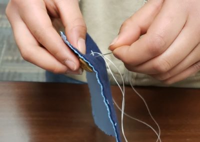 A child learns to sew on a button