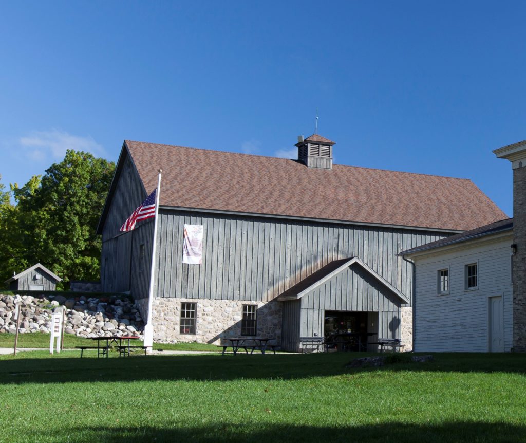 Main Building and Entrance The Sheboygan County Museum's main building was designed to look like a carriage house with gray siding and a flag.